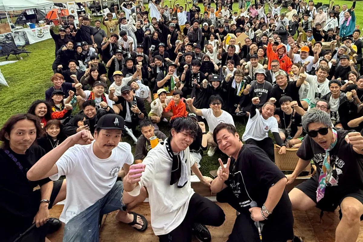 周年フェスの芝生に集まったスタッフと参加者の集合写真