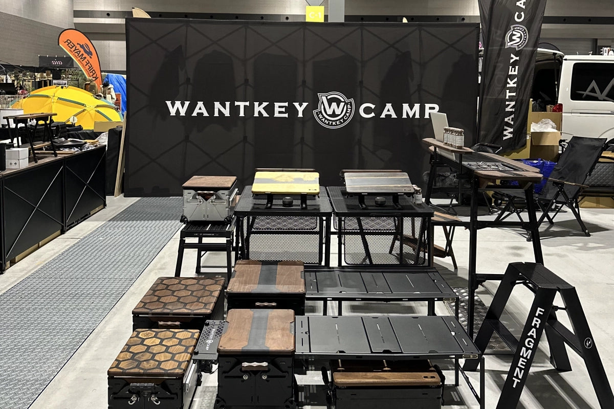 展示会場の WANTKEY CAMP ブース。黒のバックドロップとプロダクトが並んでいる